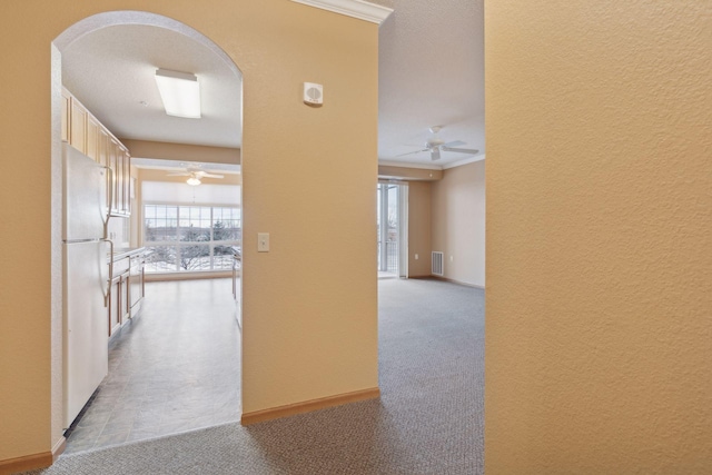 corridor featuring crown molding and light carpet