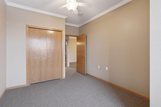 unfurnished bedroom featuring ornamental molding, carpet floors, ceiling fan, and a closet