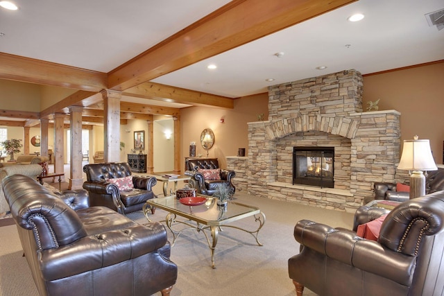 carpeted living room featuring beamed ceiling, ornamental molding, a fireplace, and ornate columns