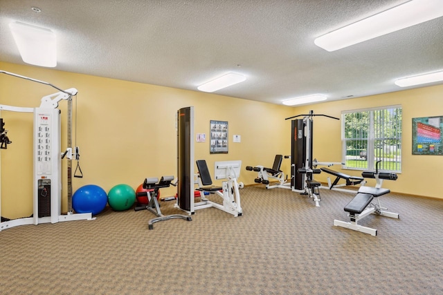 exercise room with carpet and a textured ceiling