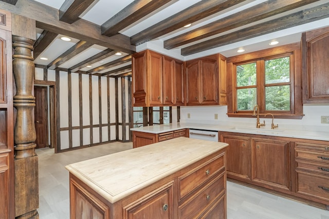 kitchen with beam ceiling, recessed lighting, brown cabinetry, white dishwasher, and a sink