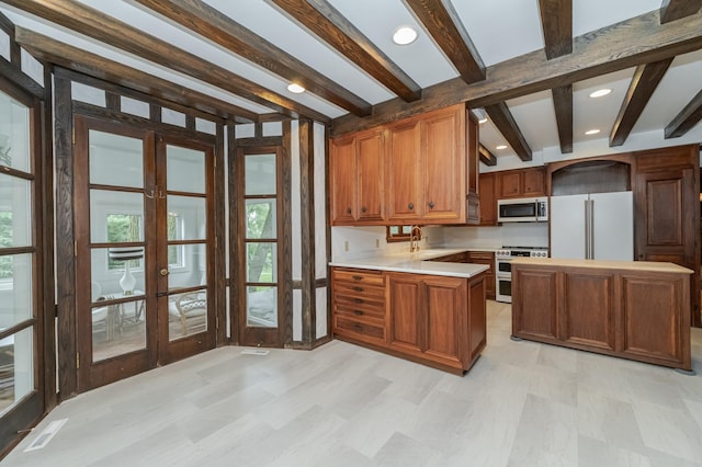 kitchen with stainless steel microwave, freestanding refrigerator, light countertops, french doors, and double oven range