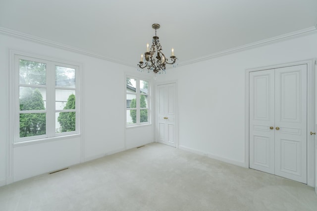 carpeted empty room featuring ornamental molding, visible vents, baseboards, and an inviting chandelier