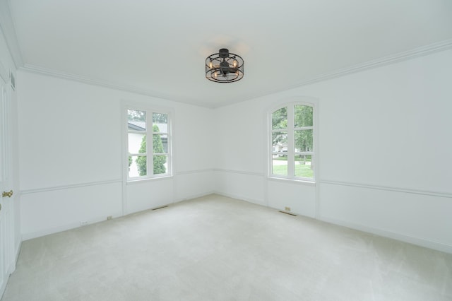 spare room with ornamental molding, carpet, and visible vents