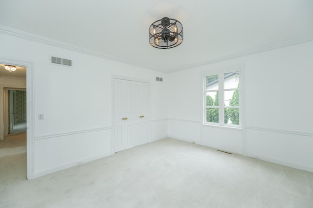 carpeted empty room with ornamental molding and visible vents