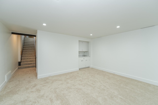 interior space with light carpet, visible vents, stairway, a sink, and recessed lighting