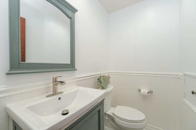 910 Folwell Dr SW, Rochester, MN 55902 - half bathroom with toilet, vanity, and a wainscoted wall