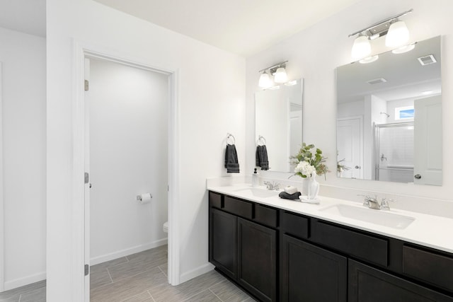 bathroom featuring vanity, toilet, and an enclosed shower