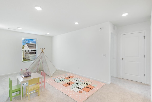 recreation room with light colored carpet