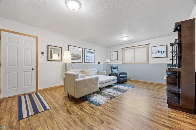 living room with a textured ceiling and light hardwood / wood-style floors