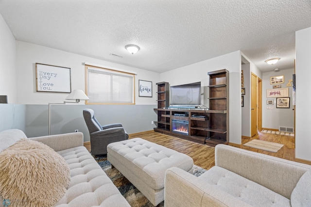 living room with hardwood / wood-style floors and a textured ceiling