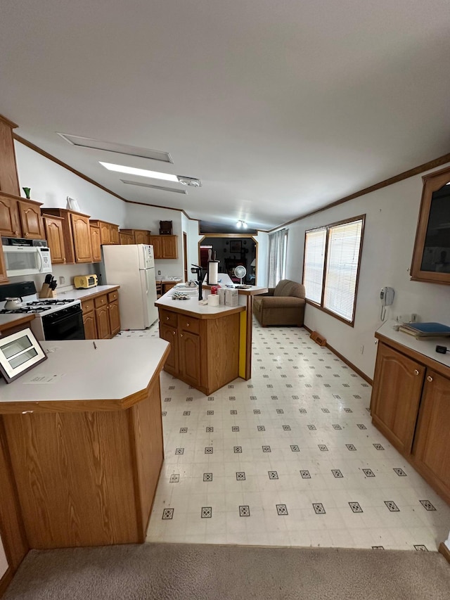 kitchen featuring white appliances, brown cabinetry, a peninsula, and crown molding