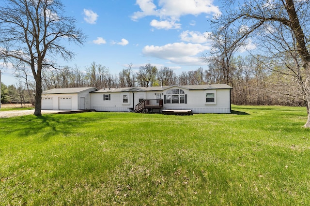 view of front of house featuring a detached garage, a front lawn, and driveway