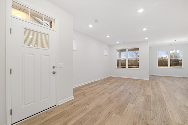 foyer entrance featuring a notable chandelier and light hardwood / wood-style flooring