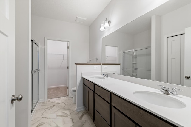 bathroom with vanity, toilet, and a shower with shower door