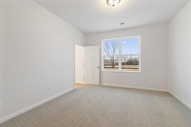 unfurnished room with carpet and a textured ceiling