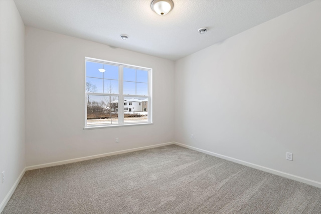 spare room with carpet and a textured ceiling