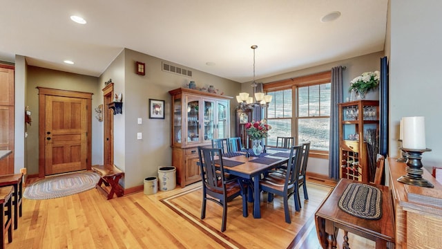 dining space featuring a chandelier and light wood-type flooring