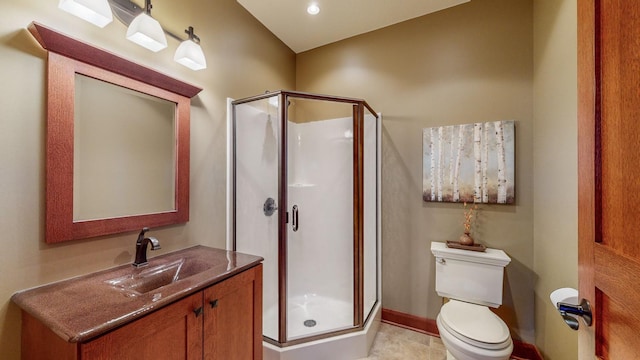 bathroom featuring a shower with door, vanity, and toilet