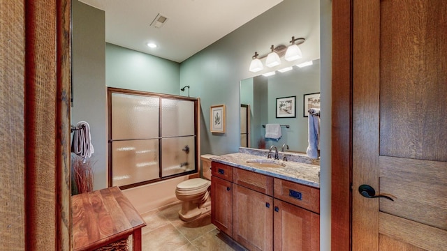 full bathroom with toilet, vanity, bath / shower combo with glass door, and tile patterned flooring