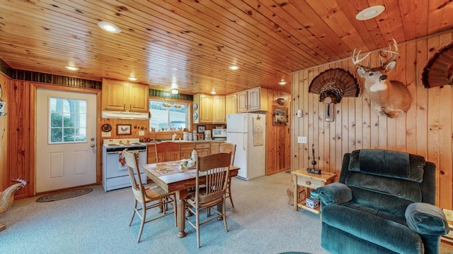 dining room with wood ceiling, light carpet, and wood walls