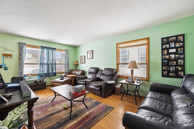 living room with a textured ceiling and light wood-type flooring