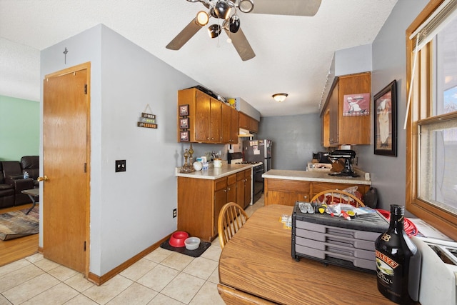 kitchen featuring ceiling fan, gas range oven, and light tile patterned floors