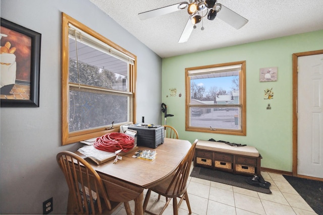 dining space with ceiling fan, light tile patterned floors, and a textured ceiling