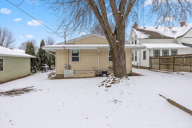 snow covered house featuring central AC unit