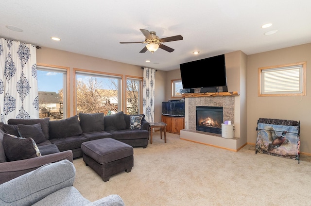 carpeted living room with a fireplace and ceiling fan