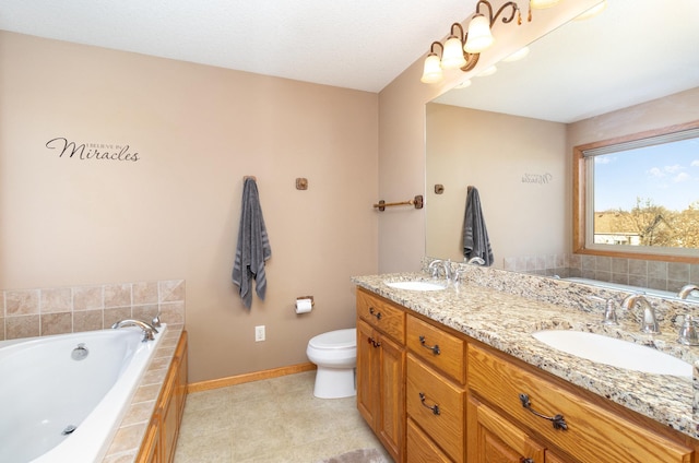 bathroom featuring a relaxing tiled tub, vanity, and toilet