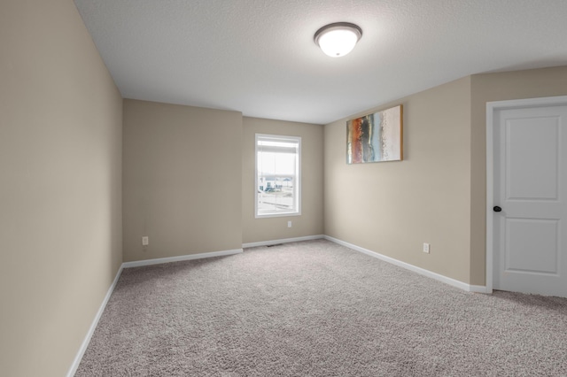 carpeted spare room with a textured ceiling