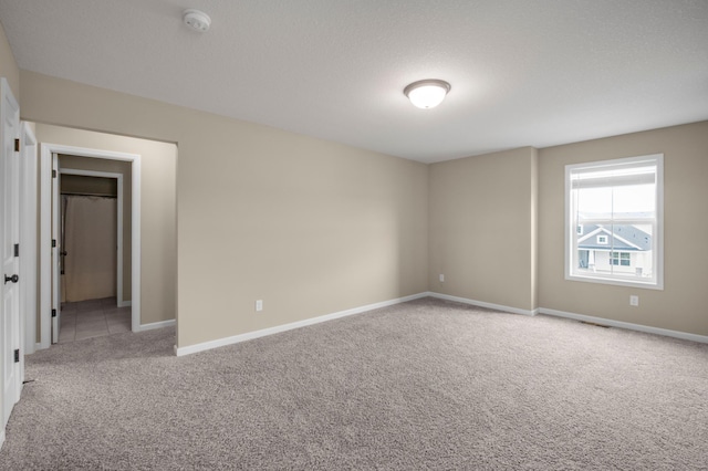 carpeted spare room with a textured ceiling