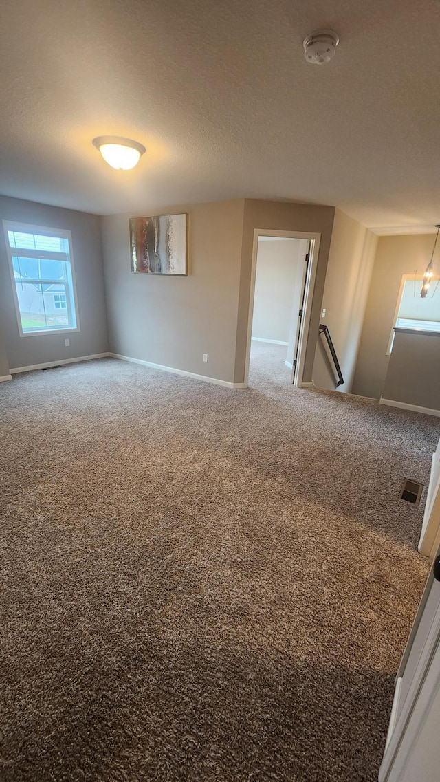 spare room with carpet and a textured ceiling