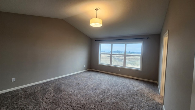 carpeted empty room featuring vaulted ceiling