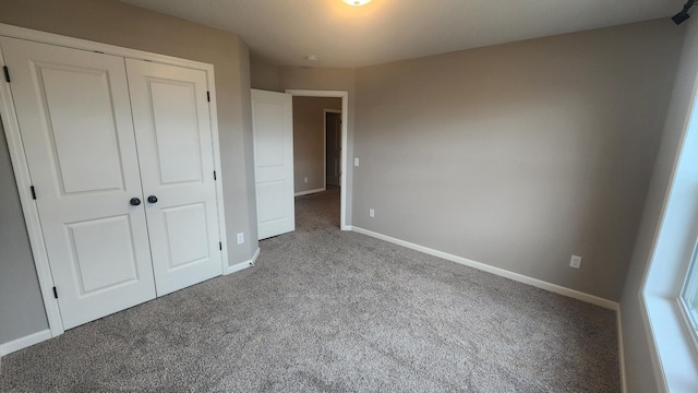 unfurnished bedroom with a closet and carpet flooring