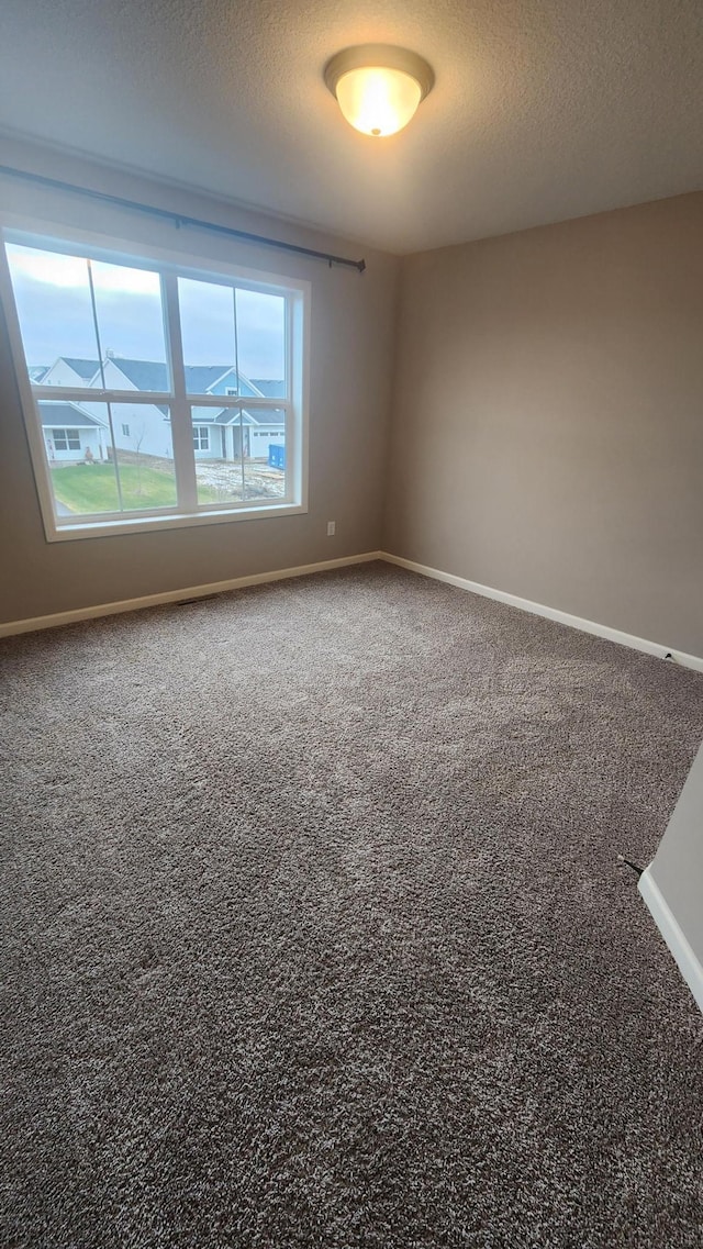 carpeted spare room featuring a textured ceiling