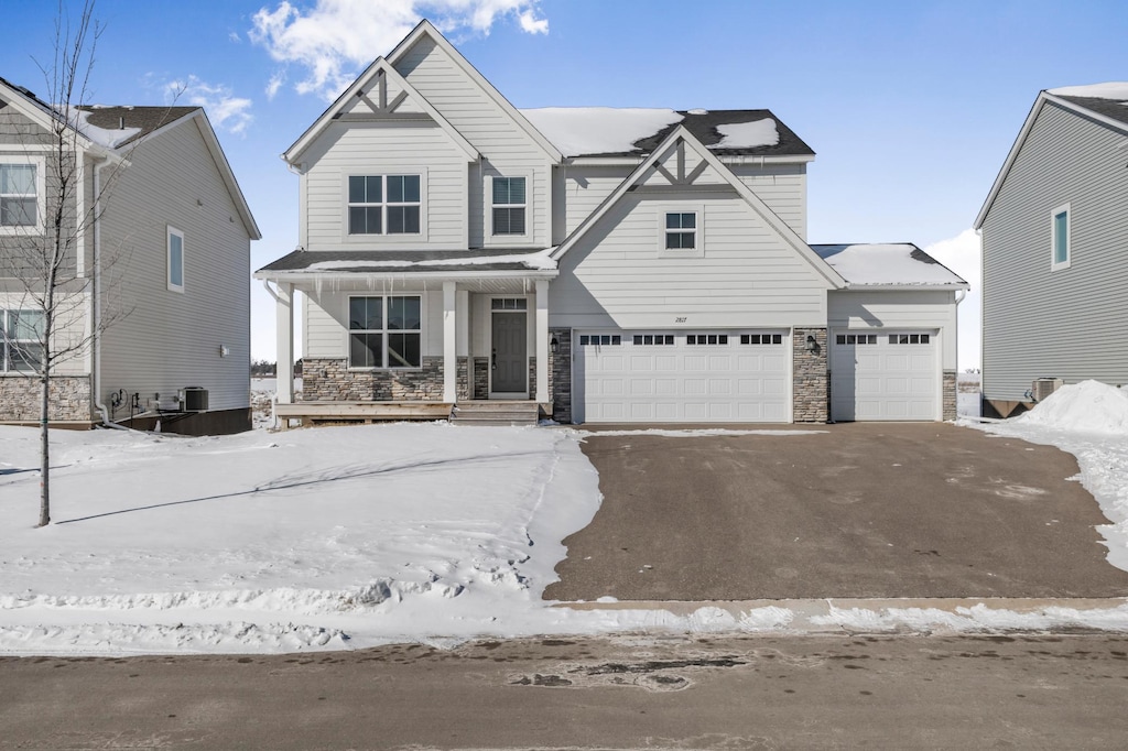 view of front of home with central AC, a garage, and a porch