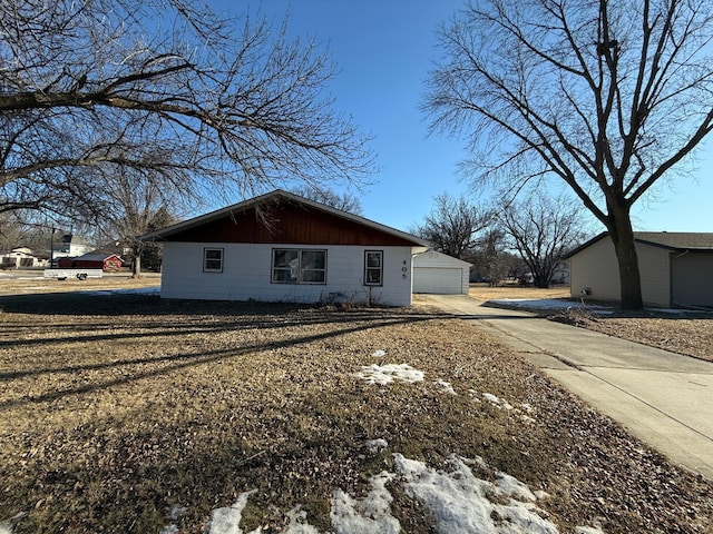 view of home's exterior with concrete driveway and a detached garage
