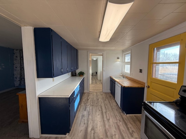 kitchen featuring stainless steel electric range oven, light countertops, a sink, and blue cabinetry