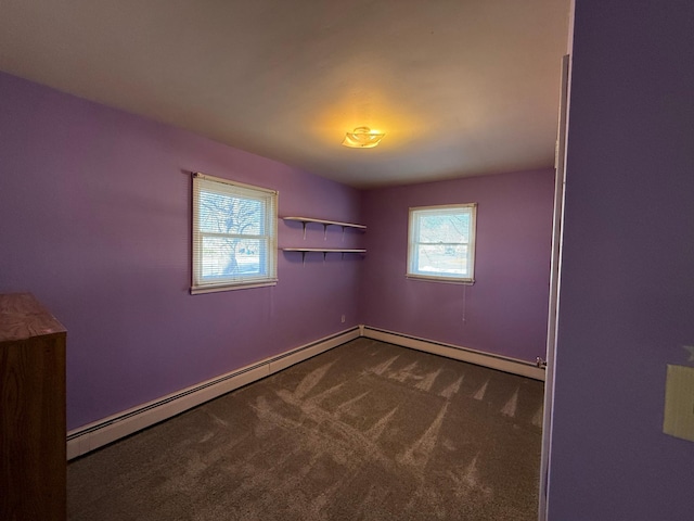 unfurnished room featuring dark carpet, baseboards, and a baseboard heating unit