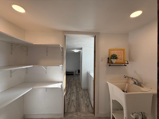 laundry area with separate washer and dryer, a sink, laundry area, and light wood-style flooring