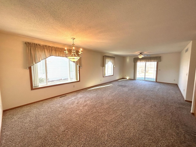 spare room with carpet floors, ceiling fan with notable chandelier, and a textured ceiling