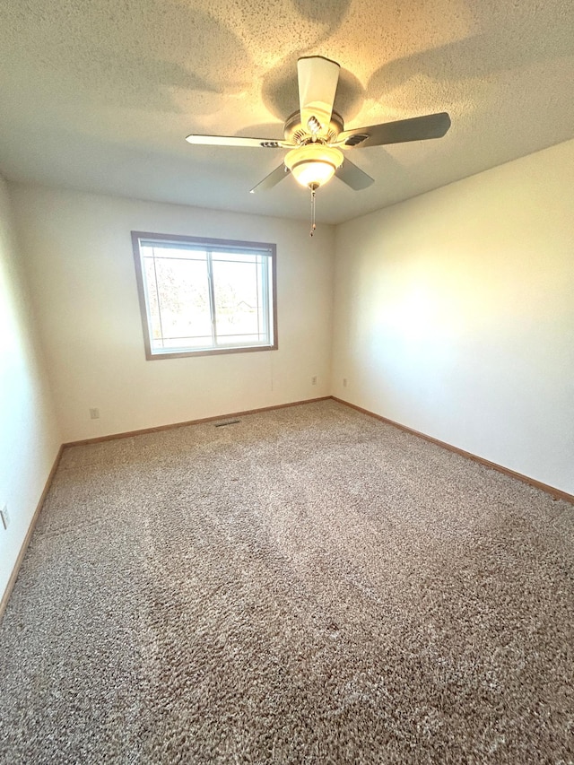 spare room featuring a textured ceiling, ceiling fan, and carpet flooring