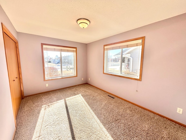 unfurnished bedroom with a closet, carpet, and a textured ceiling