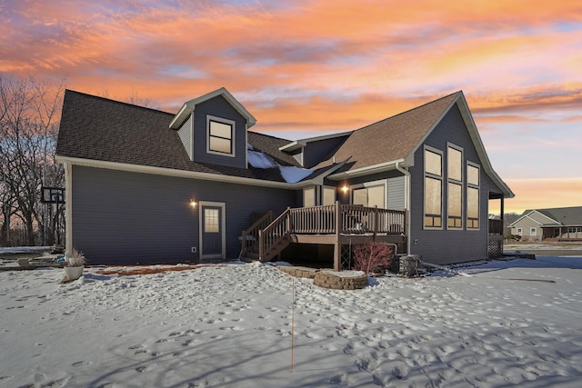 snow covered house with a wooden deck