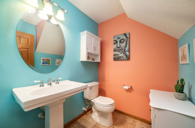 bathroom with a textured ceiling, lofted ceiling, tile patterned flooring, toilet, and baseboards