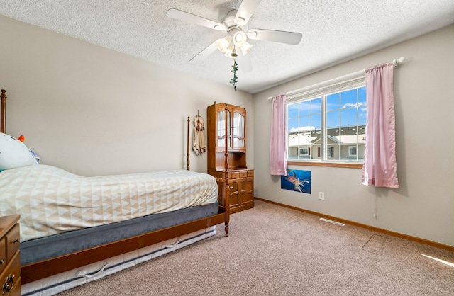 bedroom featuring a textured ceiling, carpet flooring, a ceiling fan, visible vents, and baseboards