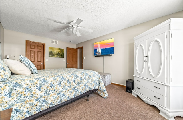 carpeted bedroom featuring a ceiling fan, visible vents, a textured ceiling, and baseboards