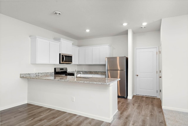 kitchen featuring appliances with stainless steel finishes, sink, white cabinets, and kitchen peninsula